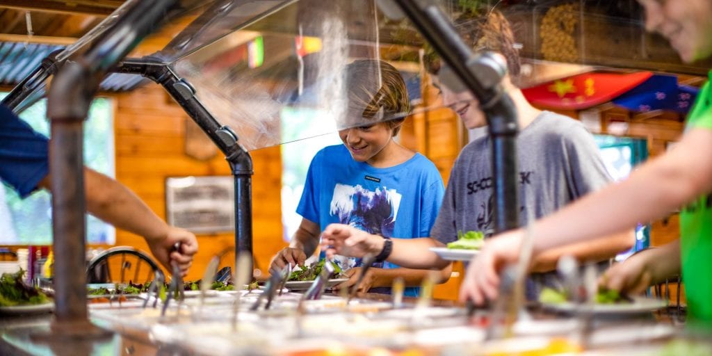 Campers get vegetables from salad bar